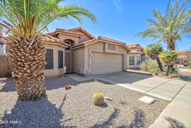 view of front of home with driveway, a tiled roof, an attached garage, and stucco siding