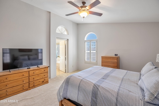 carpeted bedroom featuring lofted ceiling, ceiling fan, and connected bathroom