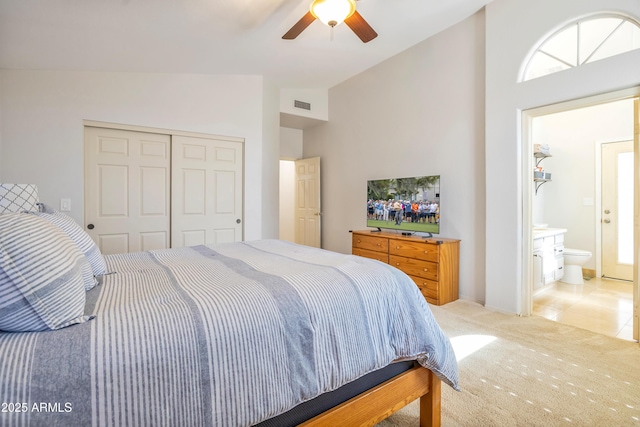 bedroom with lofted ceiling, a closet, light colored carpet, visible vents, and ceiling fan