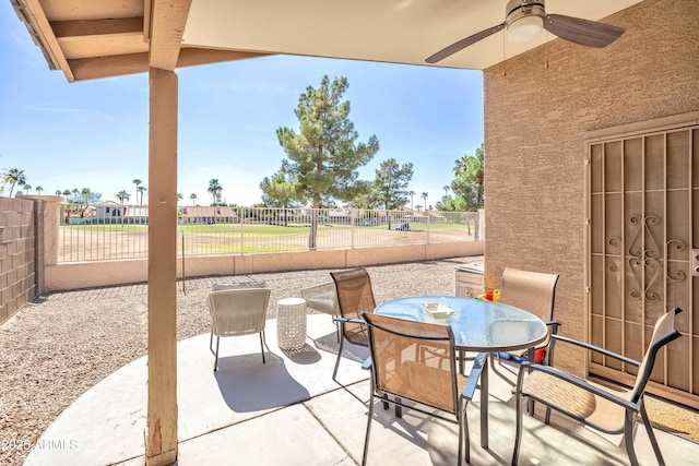 view of patio / terrace with outdoor dining space, a fenced backyard, and a ceiling fan