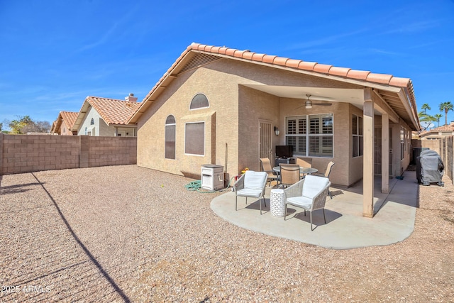 back of house with a tile roof, stucco siding, a patio area, ceiling fan, and a fenced backyard