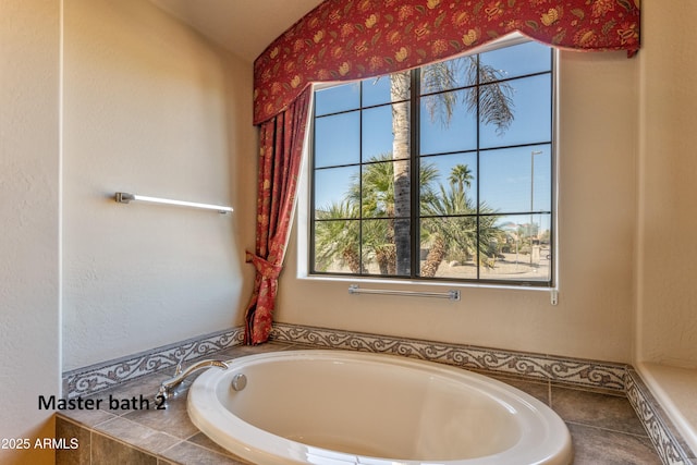 bathroom with a relaxing tiled tub