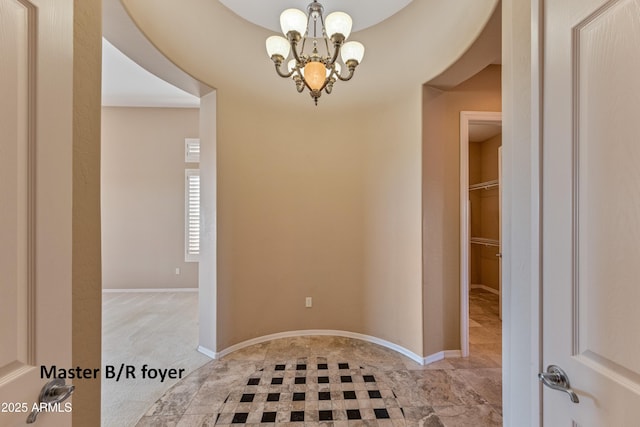 foyer entrance featuring light colored carpet and a notable chandelier