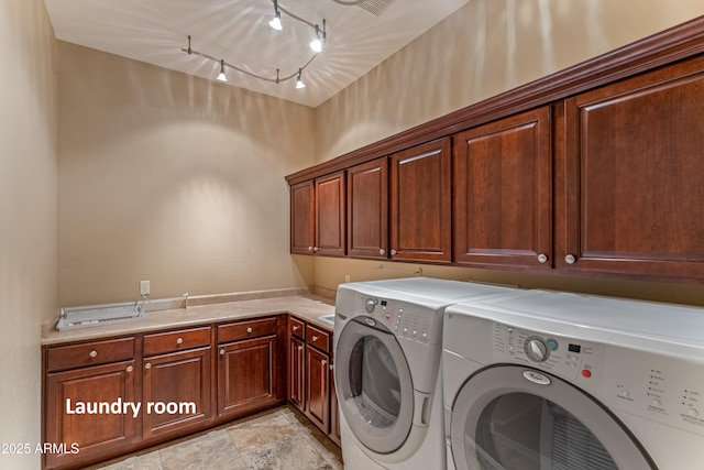 laundry area with rail lighting, washing machine and clothes dryer, and cabinets