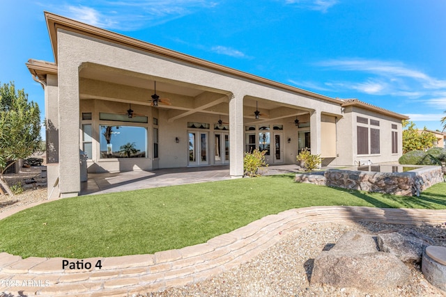 back of property featuring ceiling fan, a yard, and a patio