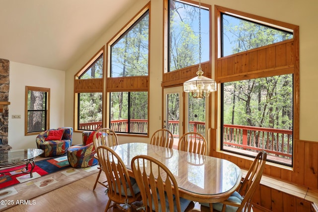 9434 W Obier Dr, Pine, AZ 85544 - dining room featuring a chandelier, wood finished floors, high vaulted ceiling, and wood walls