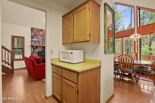 9434 W Obier Dr, Pine, AZ 85544 - kitchen featuring white microwave, light wood-style flooring, light countertops, and plenty of natural light