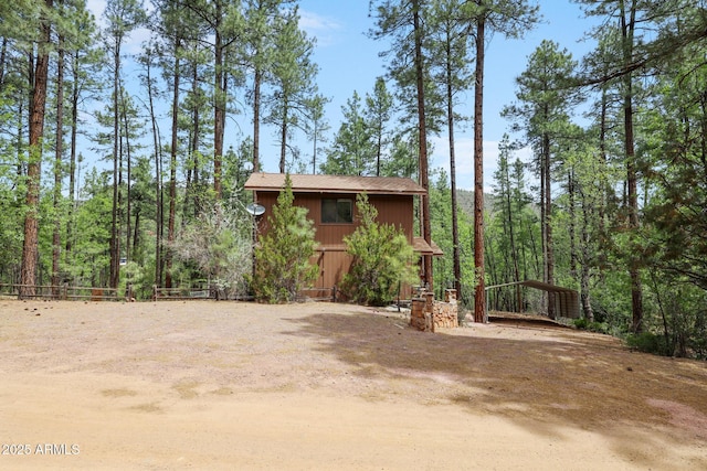 9434 W Obier Dr, Pine, AZ 85544 - view of front of house featuring a detached carport, driveway, an outbuilding, and a wooded view