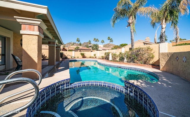 view of pool with a patio area, a fenced backyard, and a pool with connected hot tub