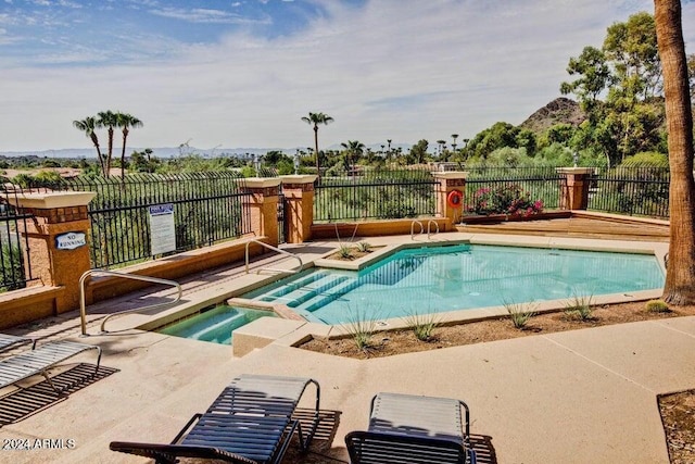 view of swimming pool featuring a patio and a hot tub