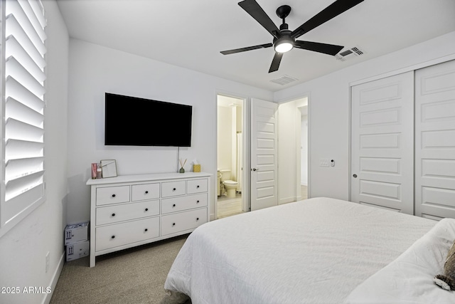 carpeted bedroom with a closet, visible vents, ceiling fan, and ensuite bathroom