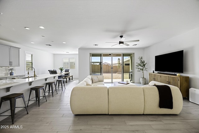 living room with light wood finished floors, recessed lighting, visible vents, and a healthy amount of sunlight