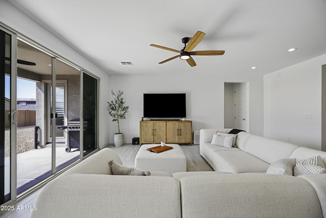 living area featuring recessed lighting, a ceiling fan, baseboards, visible vents, and light wood finished floors