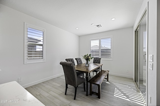 dining area with light wood-type flooring, baseboards, visible vents, and recessed lighting