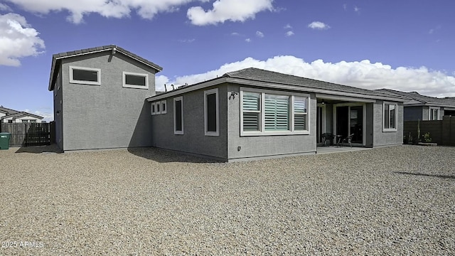 back of property with a patio, fence, and stucco siding