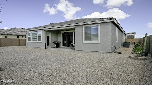 back of property with a patio area, a fenced backyard, central AC unit, and stucco siding