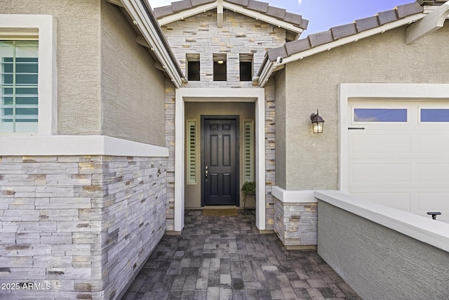 view of exterior entry featuring stone siding and stucco siding