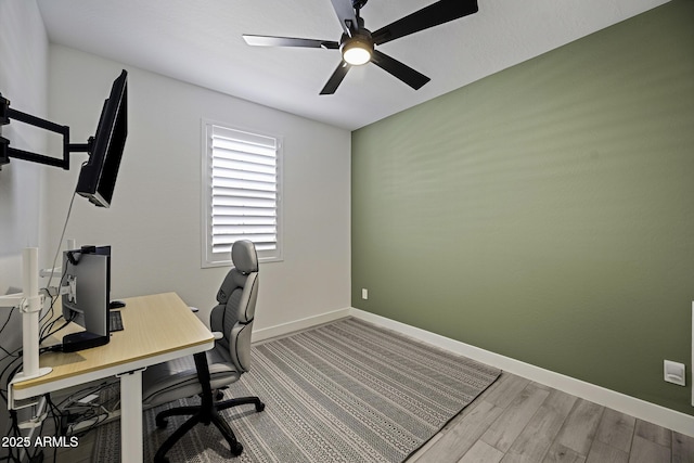 office area with a ceiling fan, baseboards, and wood finished floors