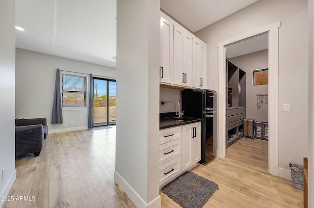 26112 N 7th Ave, Phoenix, AZ 85085 - kitchen with light wood-style flooring, white cabinets, and dark countertops