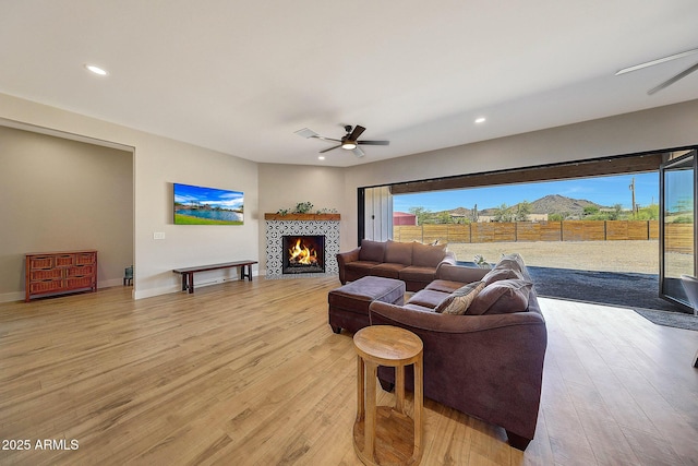 26112 N 7th Ave, Phoenix, AZ 85085 - living room featuring a ceiling fan, light wood finished floors, a tile fireplace, healthy amount of natural light, and recessed lighting