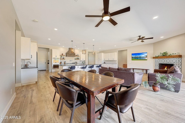 26112 N 7th Ave, Phoenix, AZ 85085 - dining room featuring ceiling fan, light wood-style flooring, recessed lighting, a fireplace, and baseboards