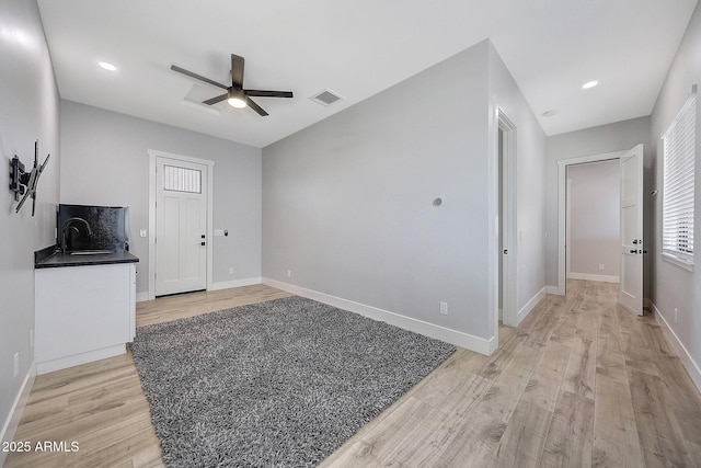 26112 N 7th Ave, Phoenix, AZ 85085 - unfurnished living room featuring a ceiling fan, light wood-style flooring, baseboards, and a sink