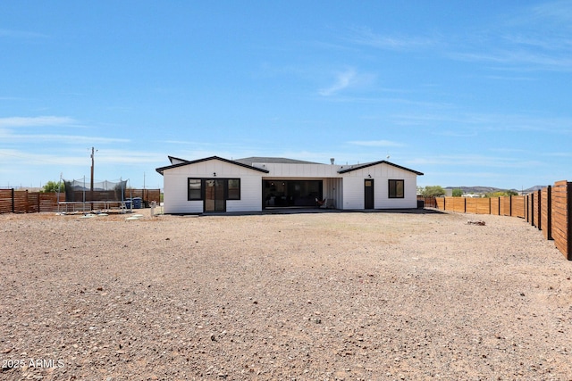 26112 N 7th Ave, Phoenix, AZ 85085 - rear view of house featuring a trampoline, board and batten siding, and a fenced backyard