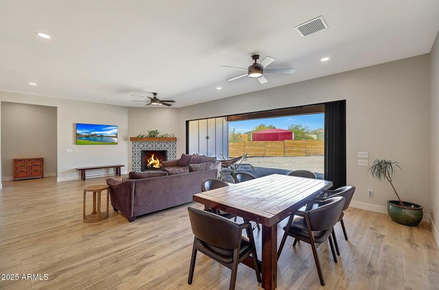 26112 N 7th Ave, Phoenix, AZ 85085 - dining space featuring ceiling fan, light wood finished floors, baseboards, recessed lighting, and a tiled fireplace