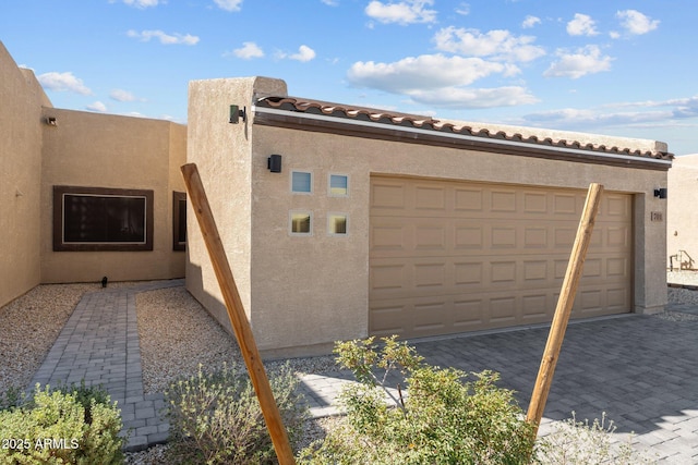 701 Dylan Ct, Wickenburg, AZ 85390 - view of side of property featuring decorative driveway, an attached garage, and stucco siding