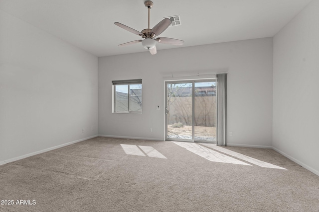 empty room featuring baseboards, visible vents, carpet floors, and ceiling fan