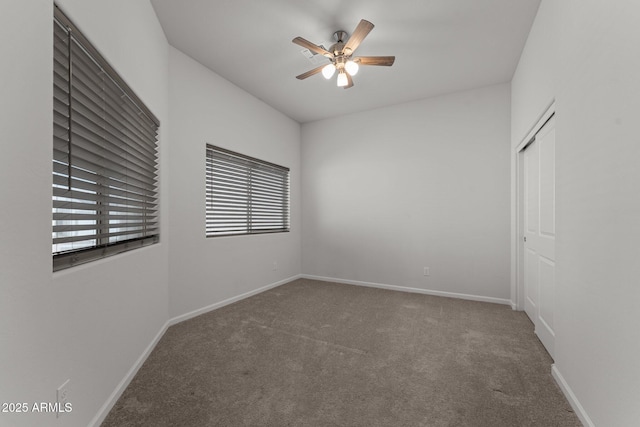 spare room with baseboards, a ceiling fan, and carpet floors