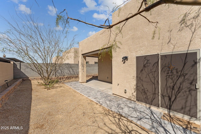 rear view of property with a patio, a fenced backyard, and stucco siding