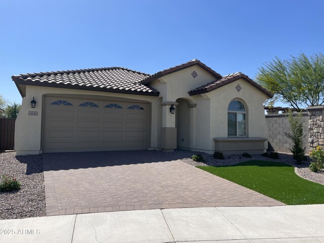24146 N 162nd Ln, Surprise, AZ 85387 - mediterranean / spanish house with stucco siding, an attached garage, decorative driveway, and a tiled roof