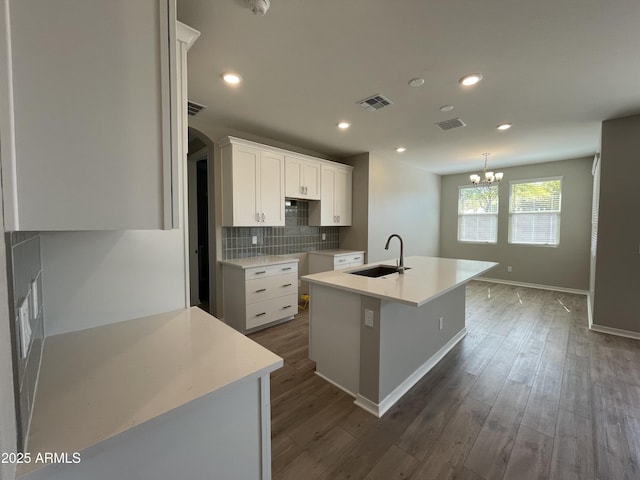 24146 N 162nd Ln, Surprise, AZ 85387 - kitchen with a sink, a chandelier, backsplash, a kitchen island with sink, and dark wood-style floors