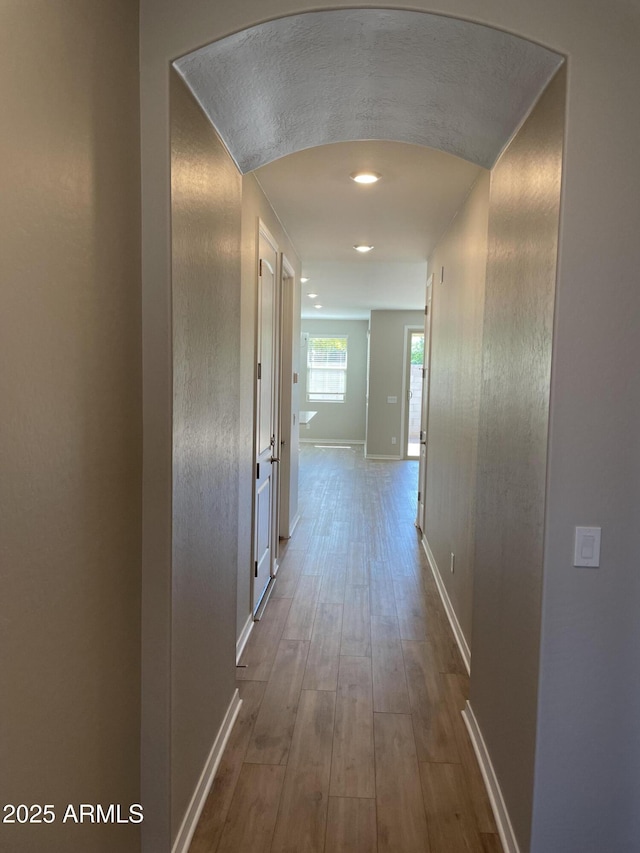 24146 N 162nd Ln, Surprise, AZ 85387 - hallway featuring dark wood-style flooring, baseboards, arched walkways, and recessed lighting