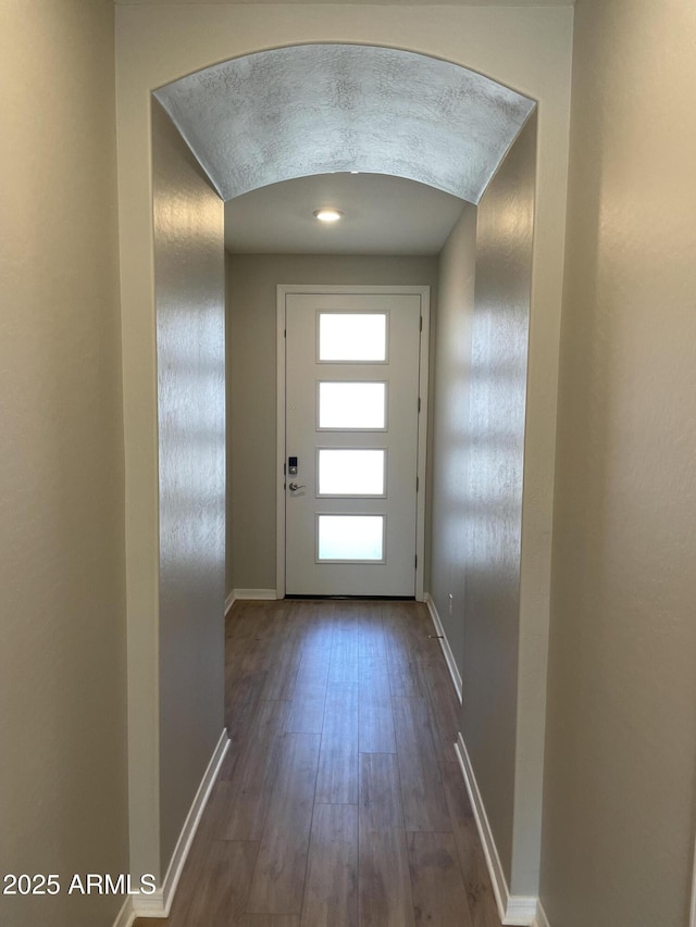 24146 N 162nd Ln, Surprise, AZ 85387 - doorway to outside with dark wood-style floors, baseboards, and arched walkways