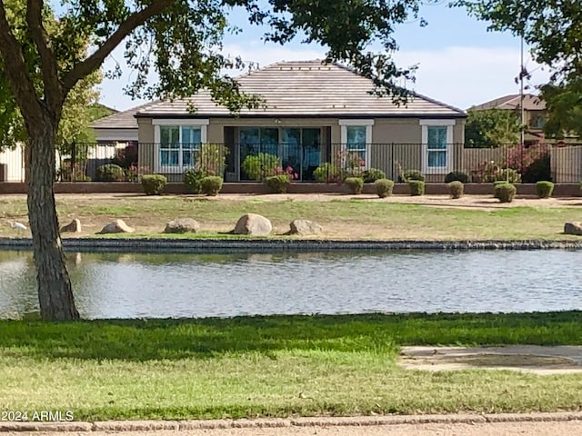 rear view of house featuring a water view and a yard