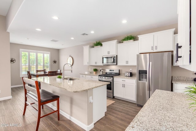 kitchen featuring white cabinetry, sink, dark wood-type flooring, a center island with sink, and appliances with stainless steel finishes