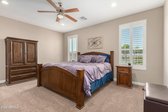 carpeted bedroom featuring ceiling fan and multiple windows