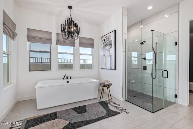 bathroom with separate shower and tub and an inviting chandelier