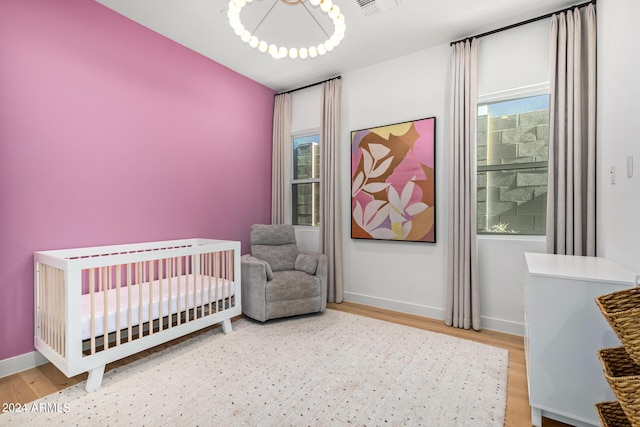 bedroom featuring a crib and wood-type flooring