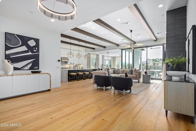 living room with radiator, beam ceiling, and light hardwood / wood-style floors