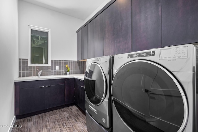 clothes washing area featuring cabinets, washer and dryer, sink, and dark wood-type flooring