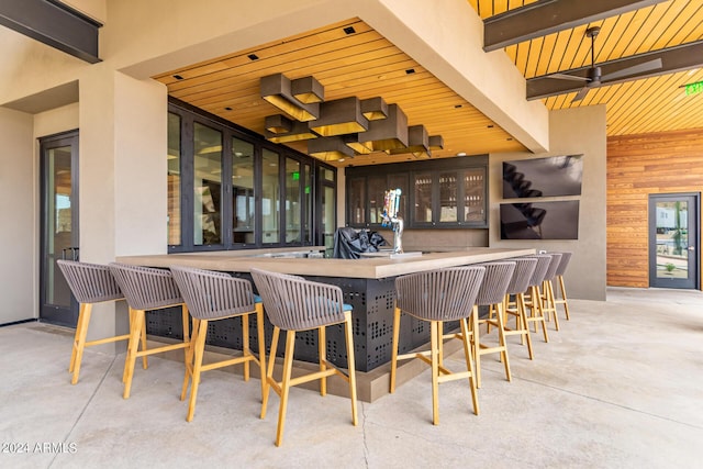 bar with wooden walls, wooden ceiling, and beamed ceiling