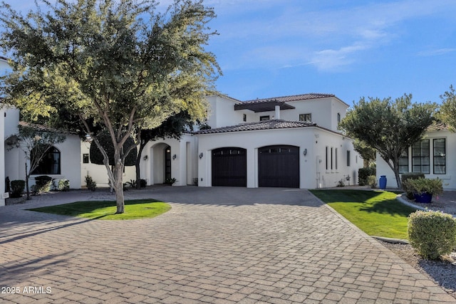 mediterranean / spanish home featuring a front lawn and a garage