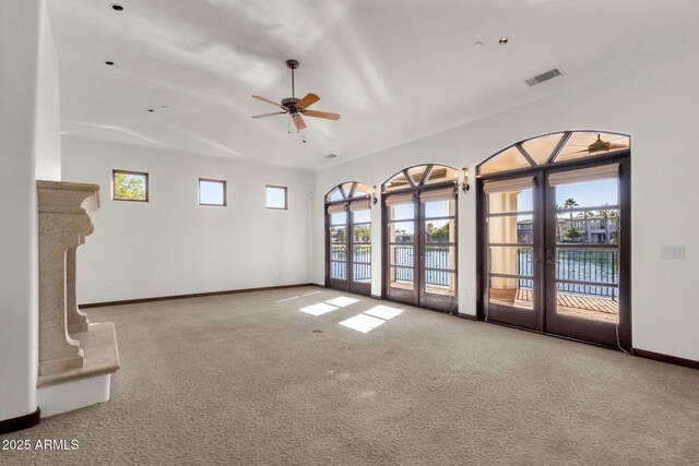 unfurnished living room featuring french doors, light carpet, and ceiling fan