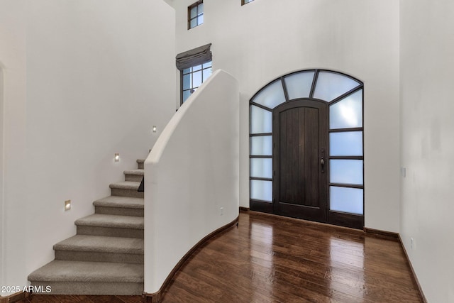 entrance foyer with a towering ceiling and dark hardwood / wood-style flooring