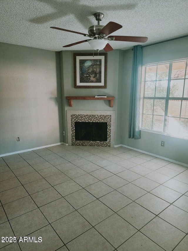 5704 E Aire Libre Ave Unit 1038, Scottsdale, AZ 85254 - unfurnished living room with a tile fireplace, a textured ceiling, ceiling fan, and tile patterned floors