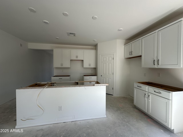 47230 W Cansados Rd, Maricopa, AZ 85139 - kitchen featuring a kitchen island, concrete floors, and white cabinets