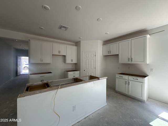 47230 W Cansados Rd, Maricopa, AZ 85139 - kitchen featuring concrete floors, a kitchen island, and white cabinets